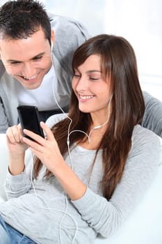 Young couple listening to music with mobile phone