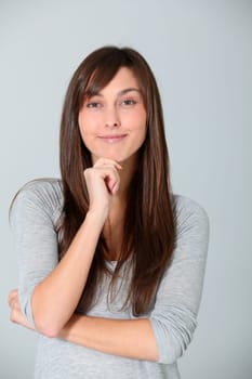 Young woman looking at camera with hand on chin