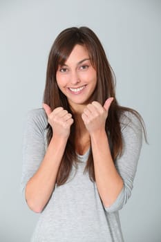 Smiling young woman with thumbs up