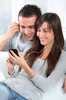 Young couple listening to music with mobile phone