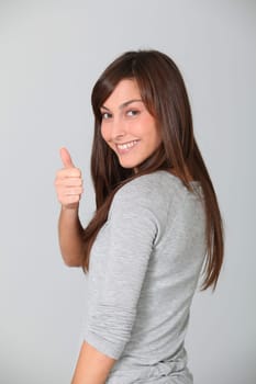 Smiling young woman with thumbs up
