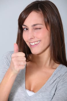 Closeup of ywinking woman with thumb up