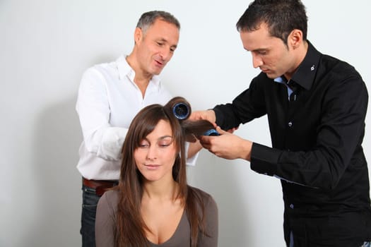 Hairdresser and trainee putting hair-curlers