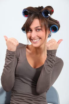 Beautiful woman with hair-curlers doing funny faces