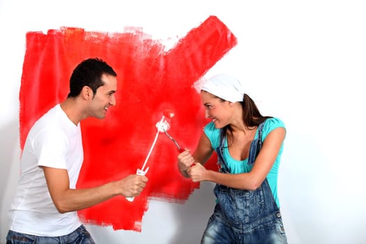 Couple having fun painting their new house
