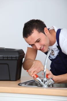 Young man fixing sink