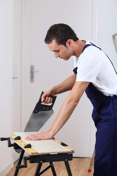 Young man working wood on workbench