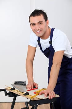 Young man working wood on workbench