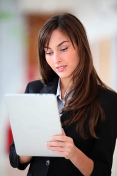 Businesswoman standing in hall with electronic pad