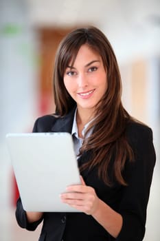Businesswoman standing in hall with electronic pad