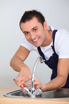 Young man fixing sink