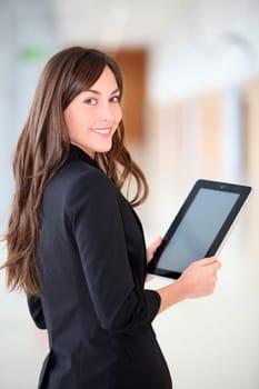 Businesswoman standing in hall with electronic pad