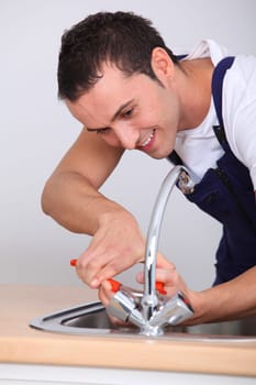 Young man fixing sink