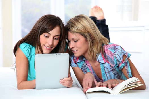 Girlfriends reading book on electronic pad
