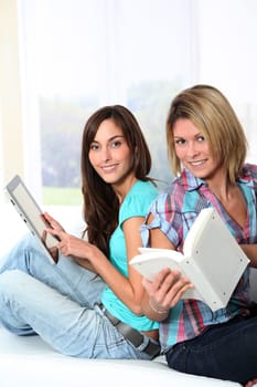 Girlfriends reading book on electronic pad
