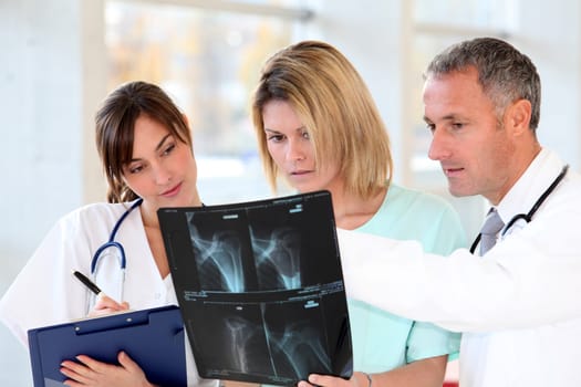 Medical team with handicapped person looking at X-ray