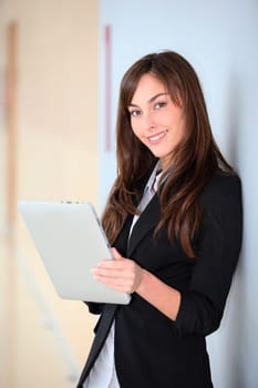 Businesswoman standing in hall with electronic pad
