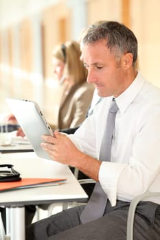 Office worker looking at internet on electronic pad