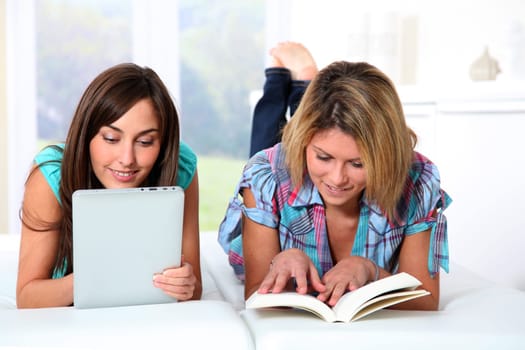 Girlfriends reading book on electronic pad