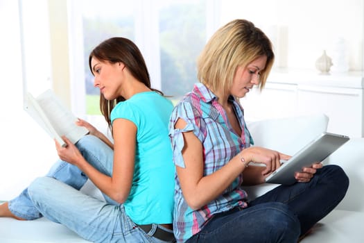 Girlfriends reading book on electronic pad