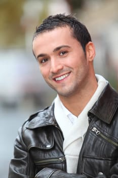 Closeup of man with leather jacket standing outside