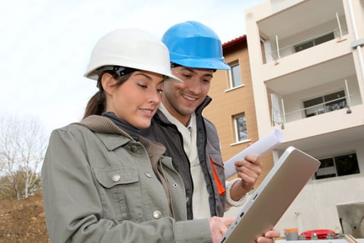Architect and engineer looking at plan on construction site