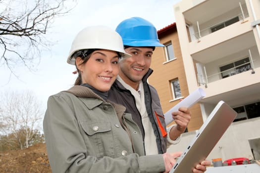 Architect and engineer looking at plan on construction site