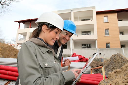Architect and engineer looking at plan on construction site