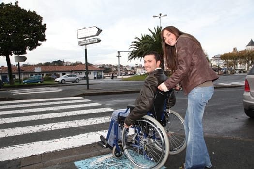 Woman helping friend in wheelchair cross the street