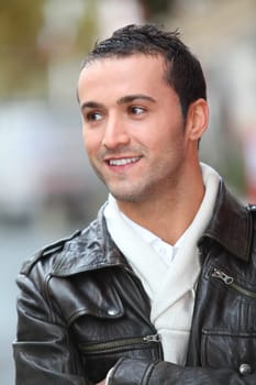 Closeup of man with leather jacket standing outside