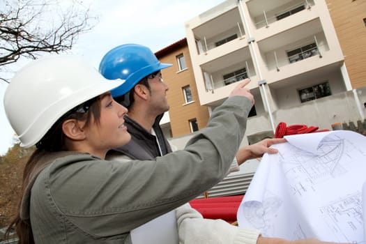 Architect and engineer looking at plan on construction site