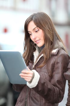 Young woman using electronic pad in town