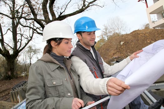 Architect and engineer looking at plan on construction site