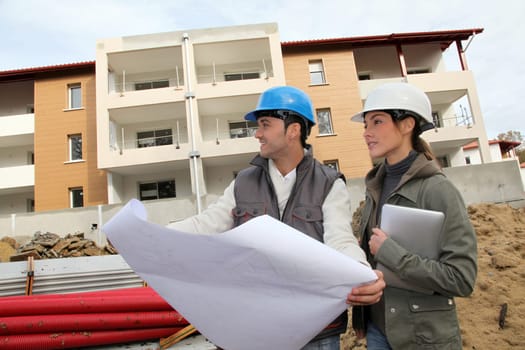 Architect and engineer looking at plan on construction site