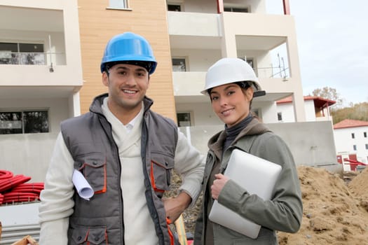 Architect and engineer looking at plan on construction site