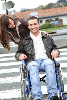 Woman helping friend in wheelchair cross the street