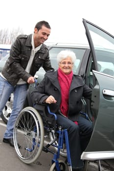 Young man assisting senior woman in wheelchair