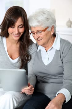 Elderly woman with grandaughter with laptop computer