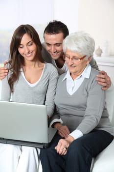 Elderly woman with grandchildren looking at laptop computer