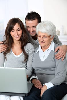 Elderly woman with grandchildren looking at laptop computer