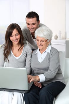 Elderly woman with grandchildren looking at laptop computer