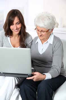 Elderly woman with grandaughter with laptop computer