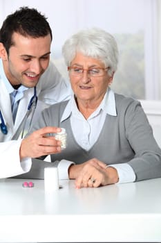 Doctor explaining drugs prescription to elderly woman