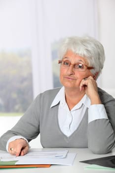 Elderly woman having trouble filling in paperwork