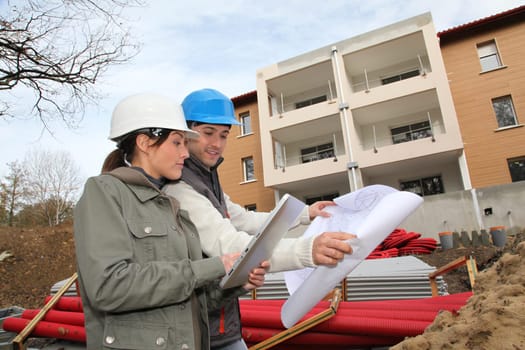Architect and engineer looking at plan on construction site
