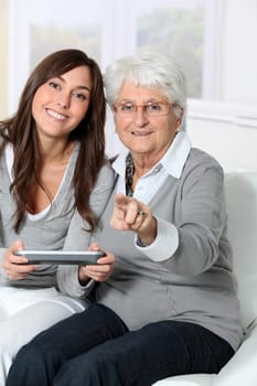 Young woman playing video game with grandmother