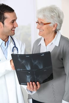 Doctor showing x-ray results to elderly woman