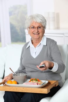 Elderly woman sitting in sofa  with lunch tray