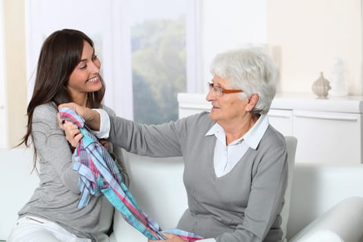 Young woman showing new clothes to grandmother
