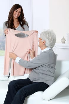 Young woman showing new clothes to grandmother